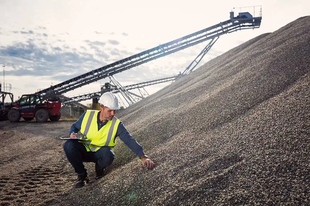 batch plant manager inspecting aggregrate